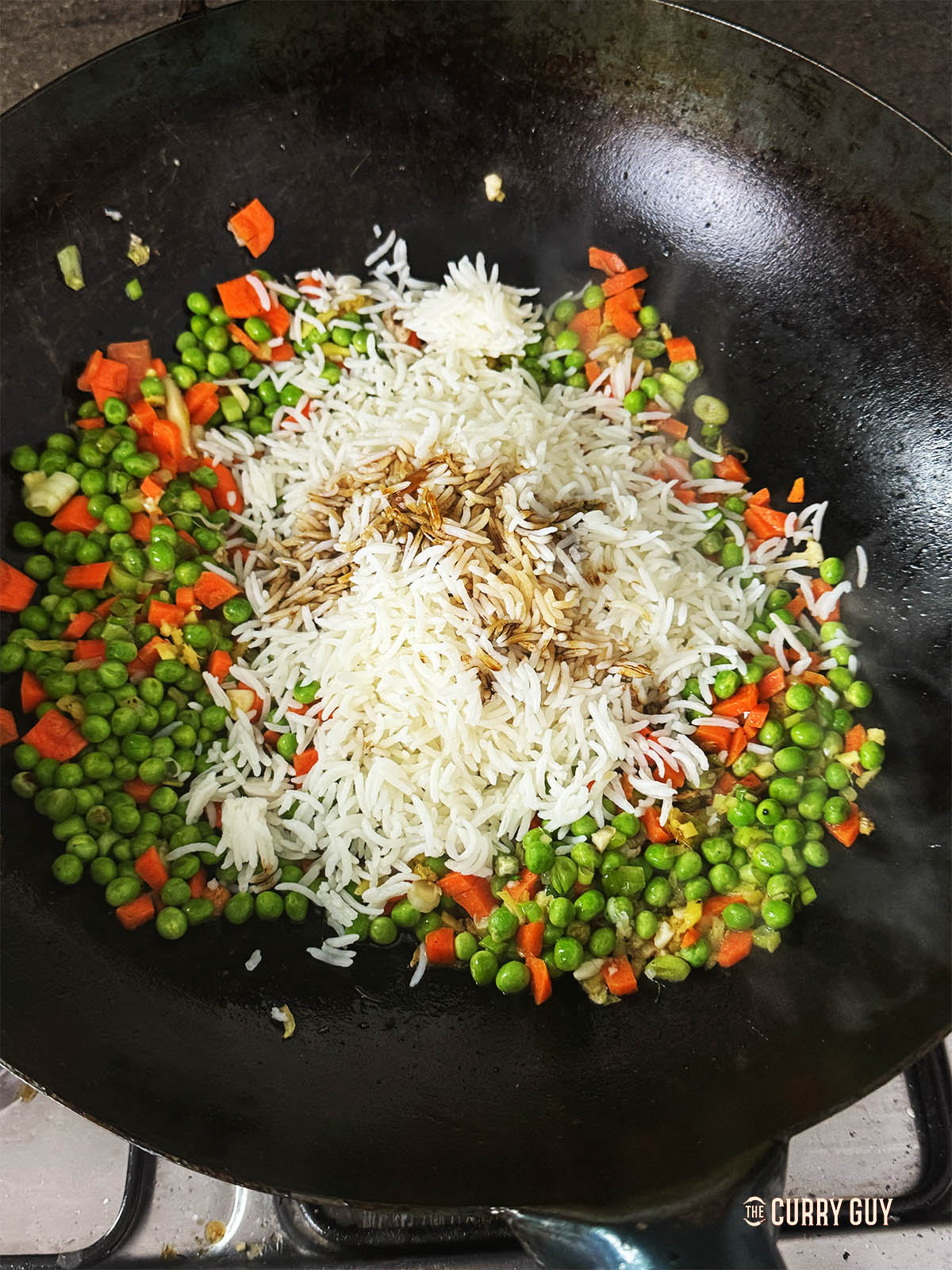 Adding the rice to the wok.