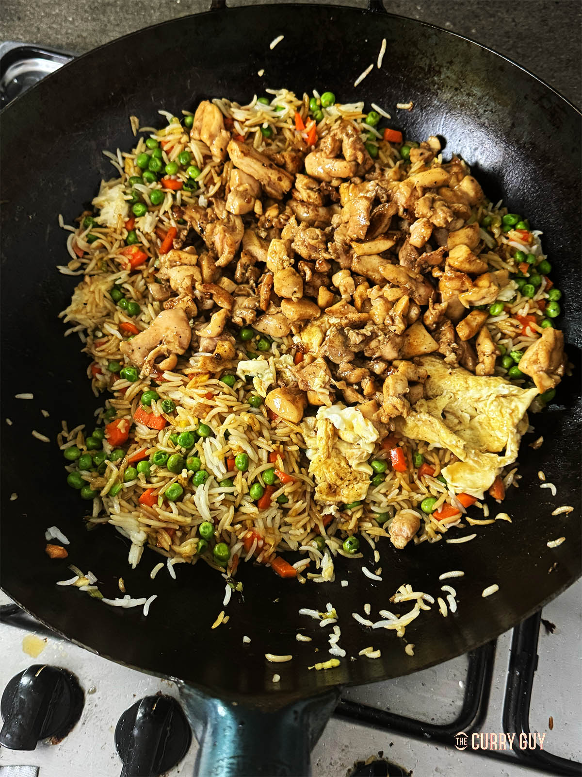 Stirring the contents of the wok to cook through.