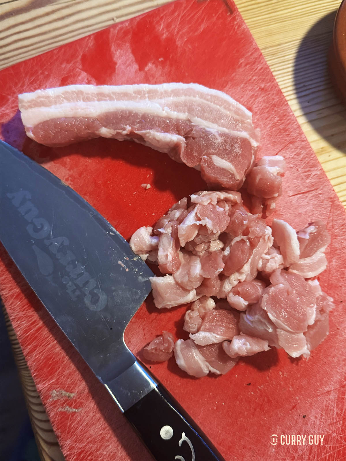 Slicing the pork belly thinly to fry. 