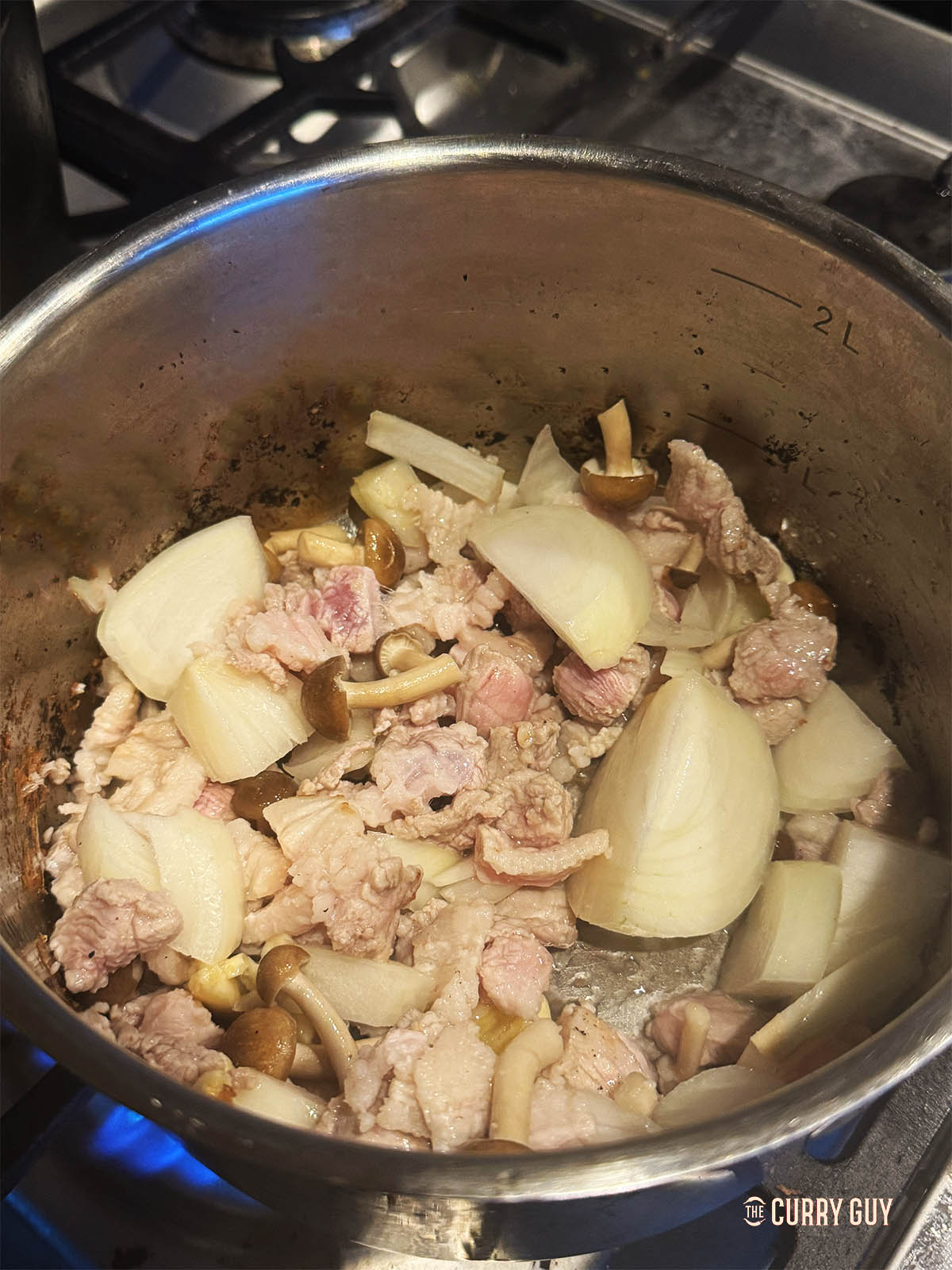 Adding the onions and garlic to the pan to fry for another few minutes. 