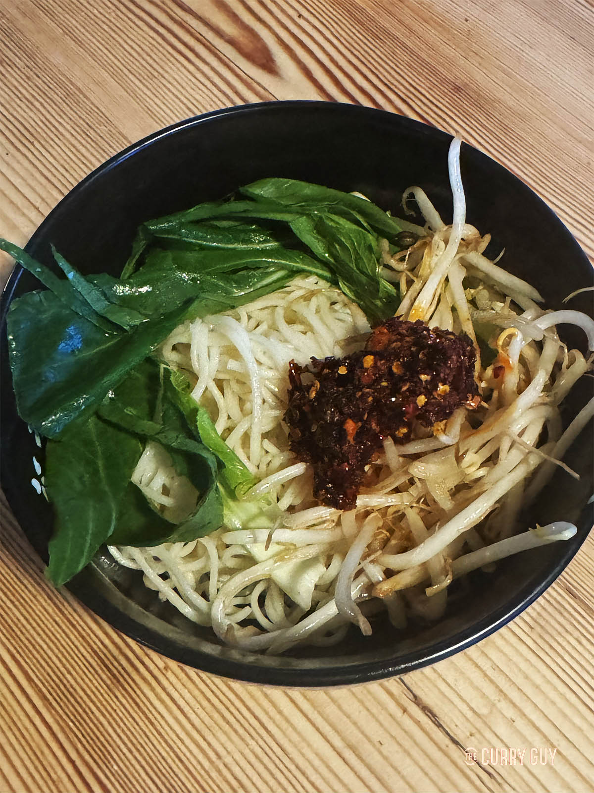 Preparing the bowl with noodles and vegetables to pour the ramen broth over the top. 
