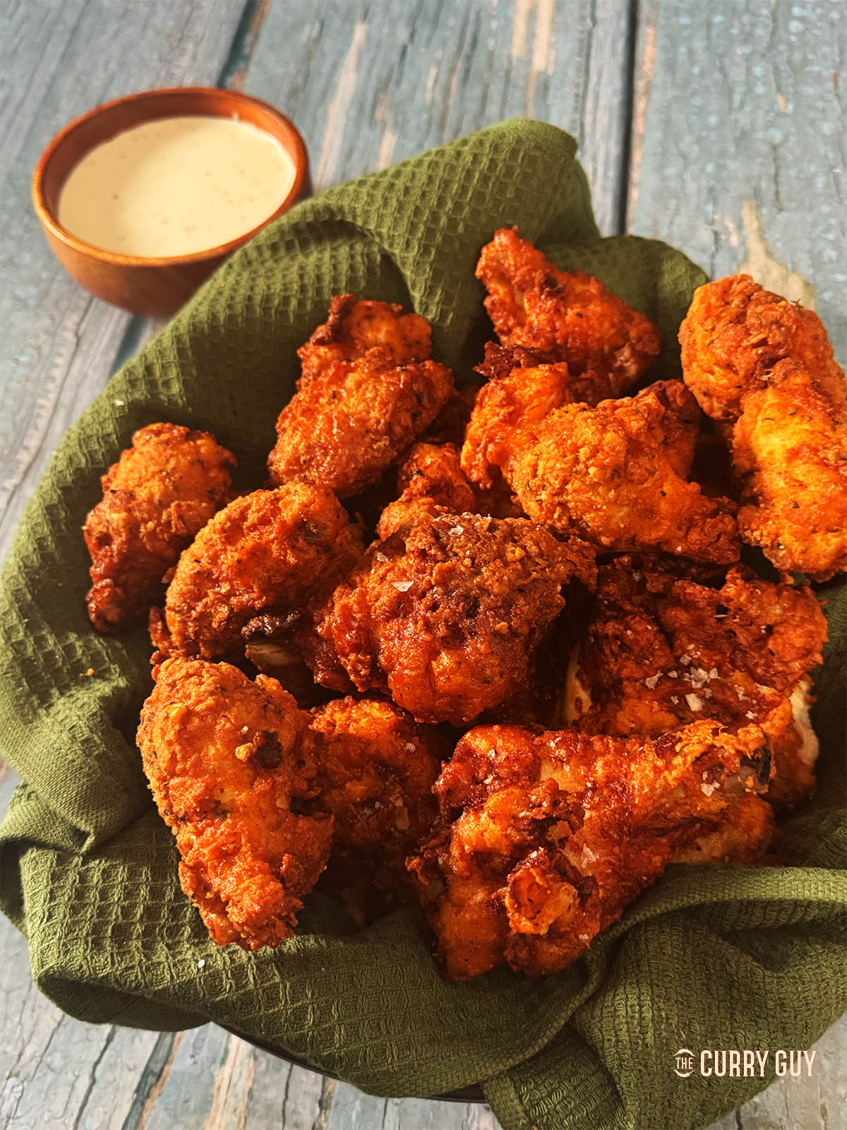 Southern fried chicken in a serving basket next to ranch dressing.