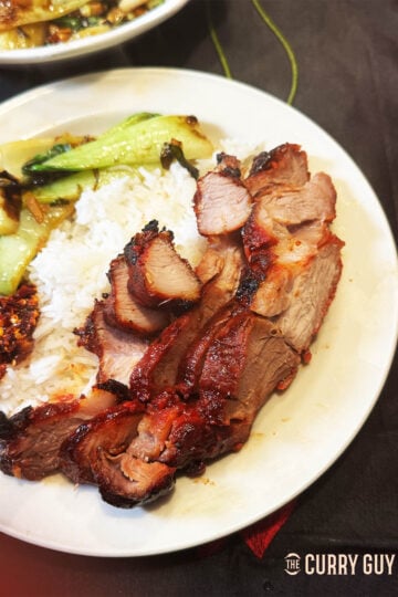 Char Siu on a serving plate with rice, bok choy and Chinese crispy chilli.