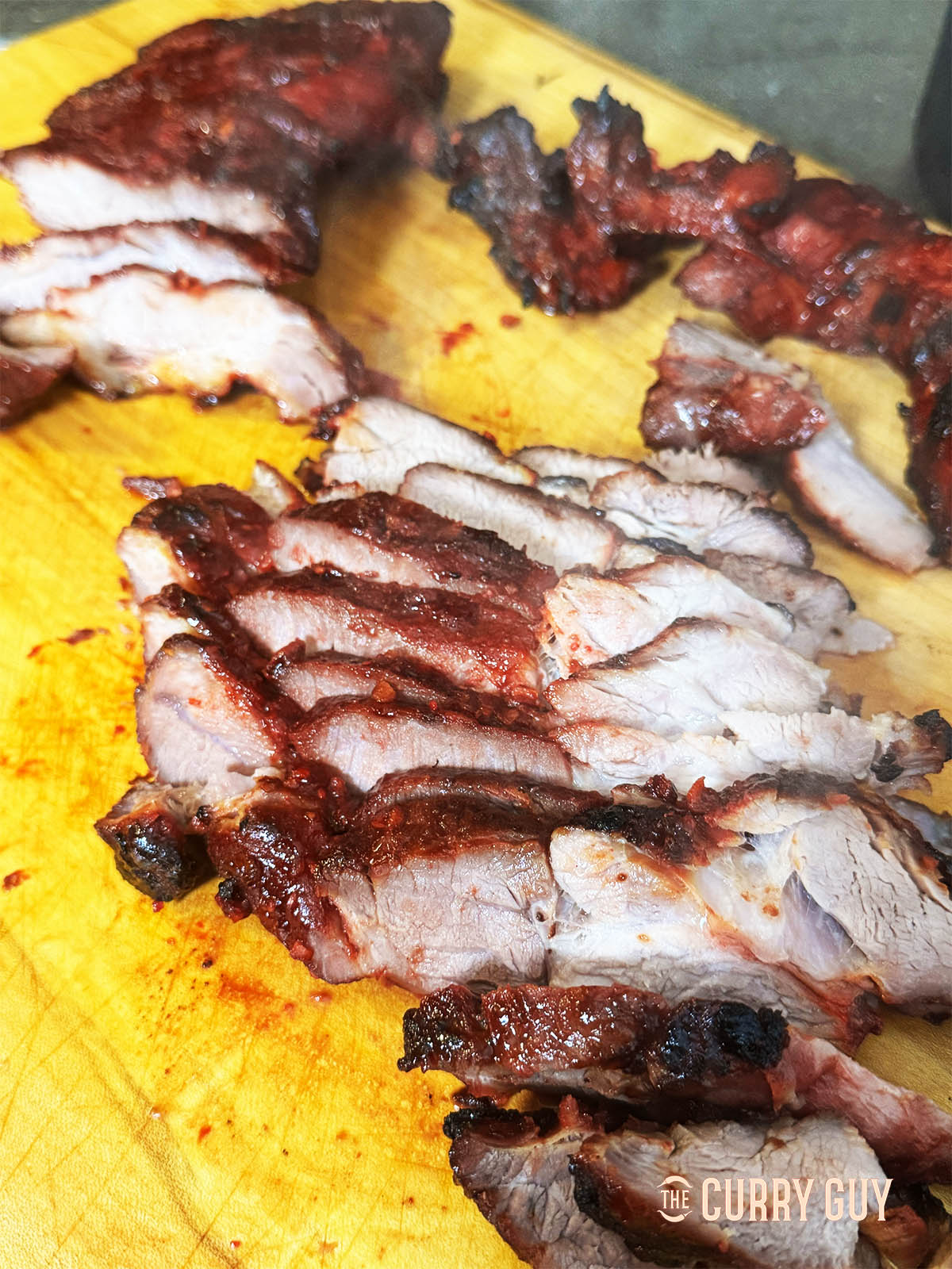 The sliced char siu on a cutting board.
