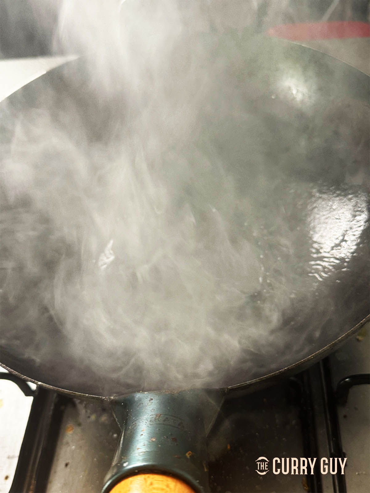 A very hot, smoking wok over the burner.