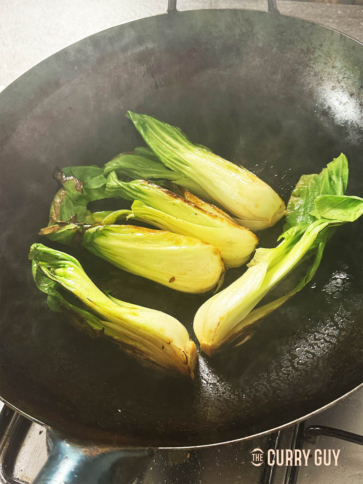 Searing the bok choy in the wok.