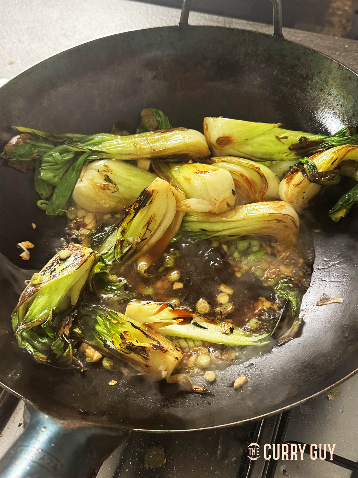 Adding the liquid ingredients to the wok.