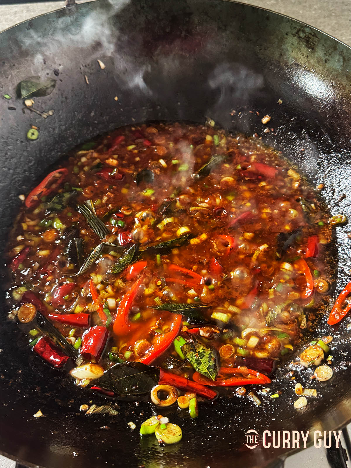 Adding the chilli sauce and bringing it to a simmer.
