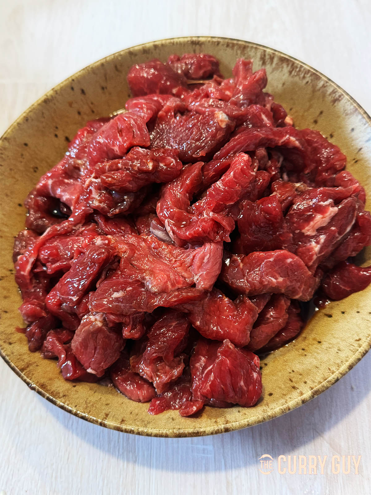 Marinating the beef in soy sauce.