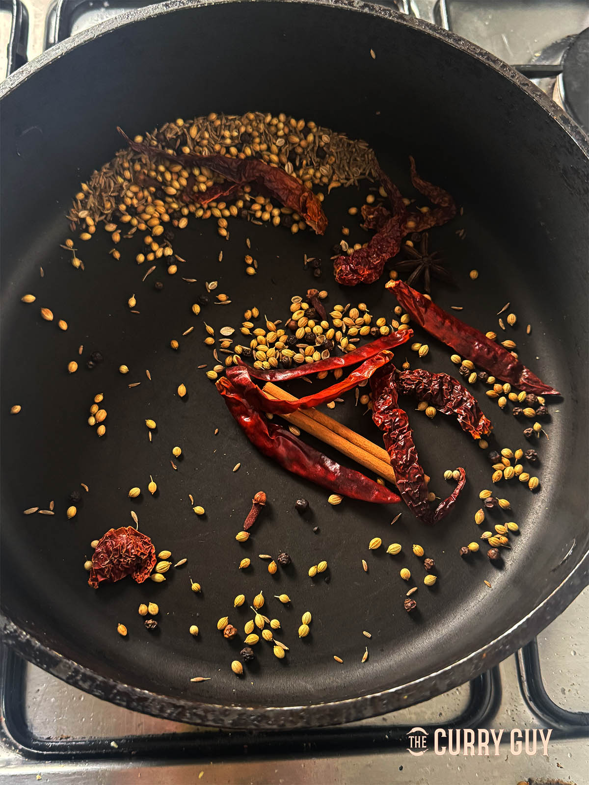 Toasting the other whole spices and dried chillies in the pan.