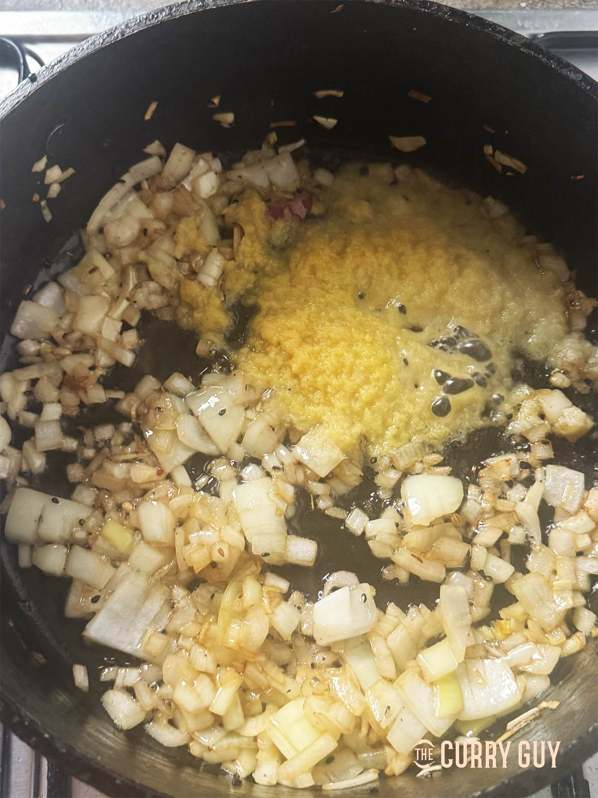 Frying the chopped onions with the garlic and ginger paste in the pan.