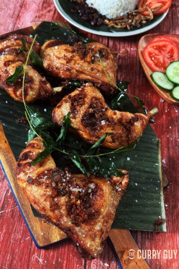 Malaysian fried chicken garnished with fried curry leaves.