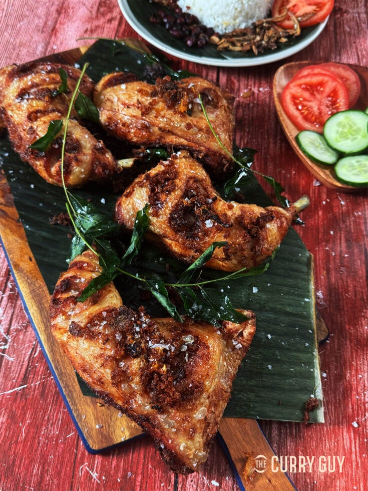 Malaysian fried chicken garnished with fried curry leaves.