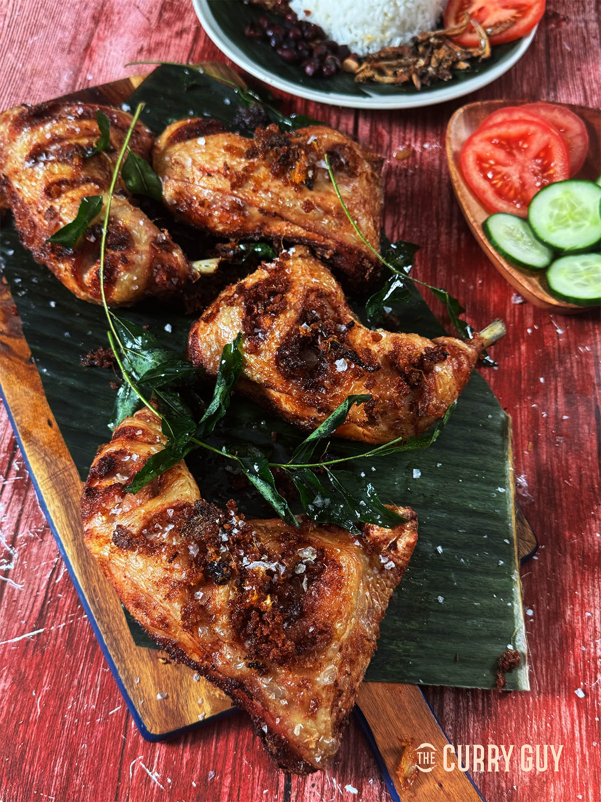 Malaysian fried chicken garnished with fried curry leaves.