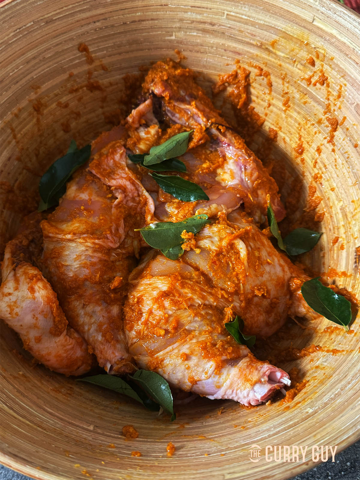 Marinating the chicken with the marinade and a few curry leaves. 