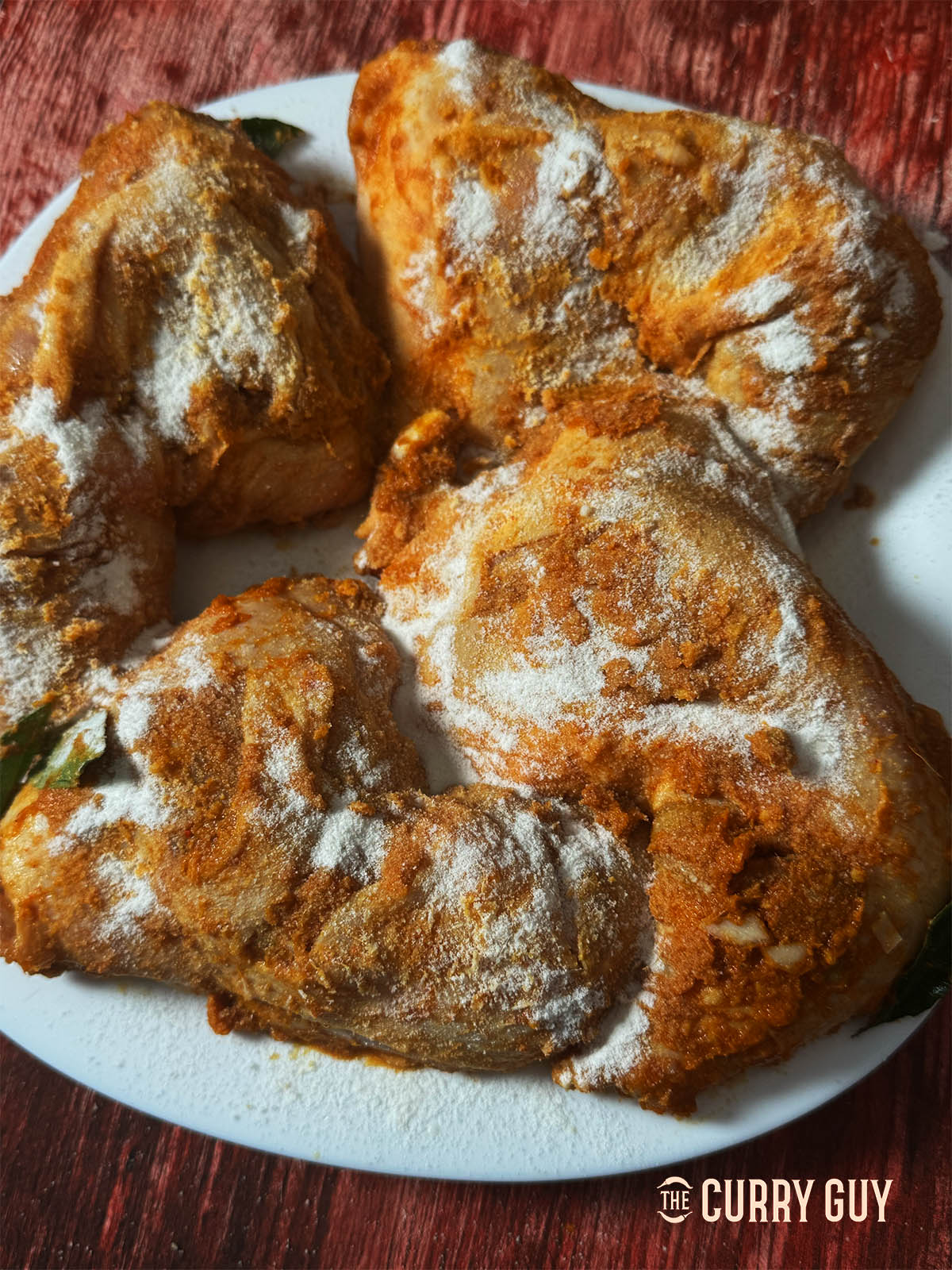 Sprinkling the marinated chicken with rice flour for extra crispiness.