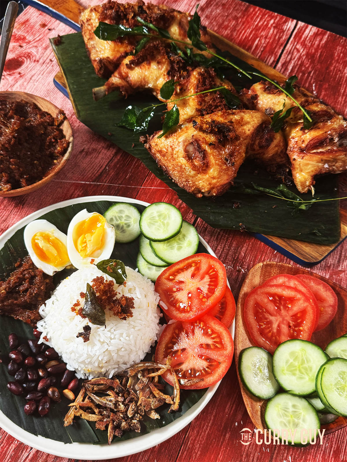 Nasi Lemak served on a plate next to Malaysian chicken.