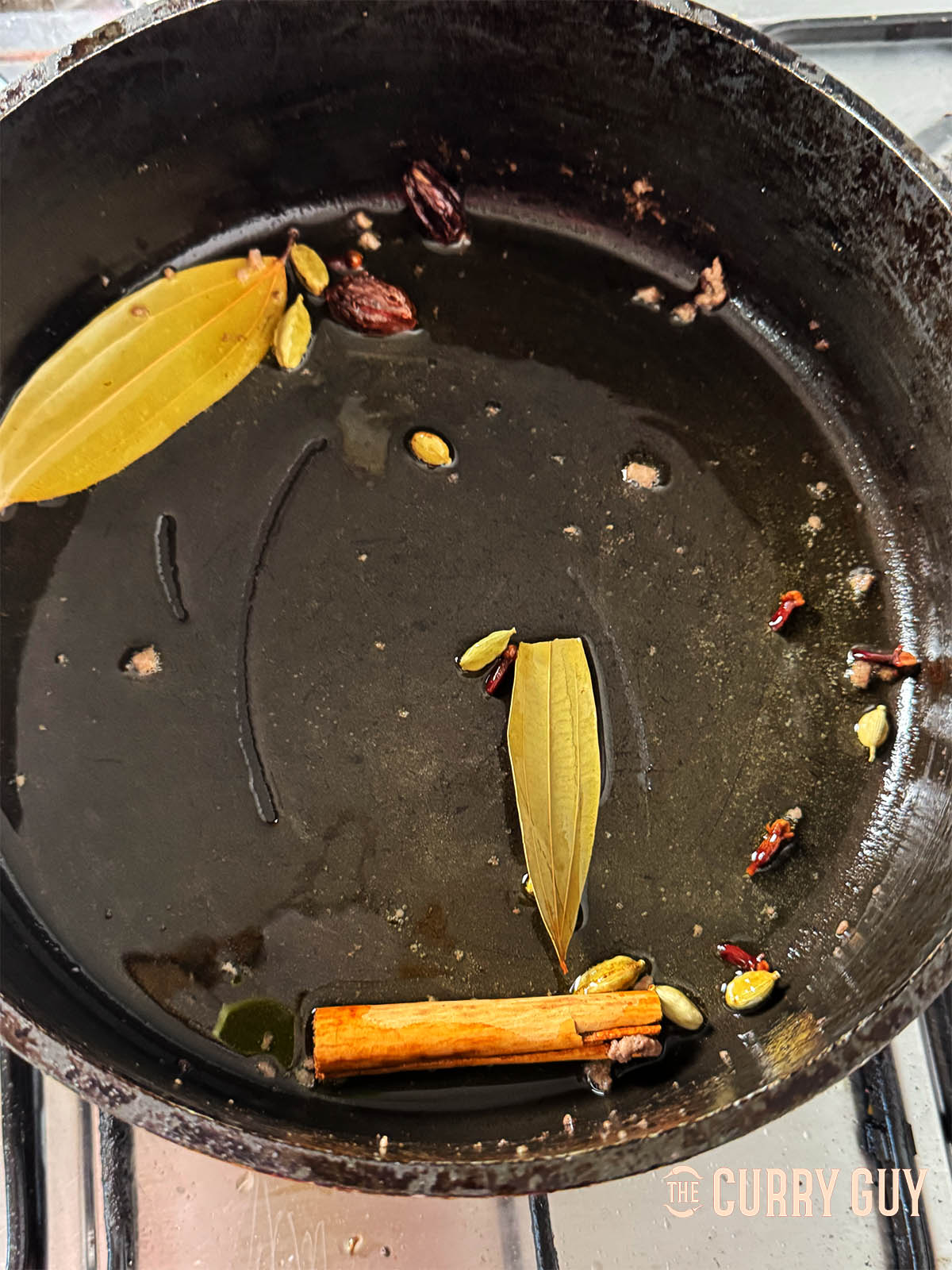 Infusing whole spices in hot ghee.