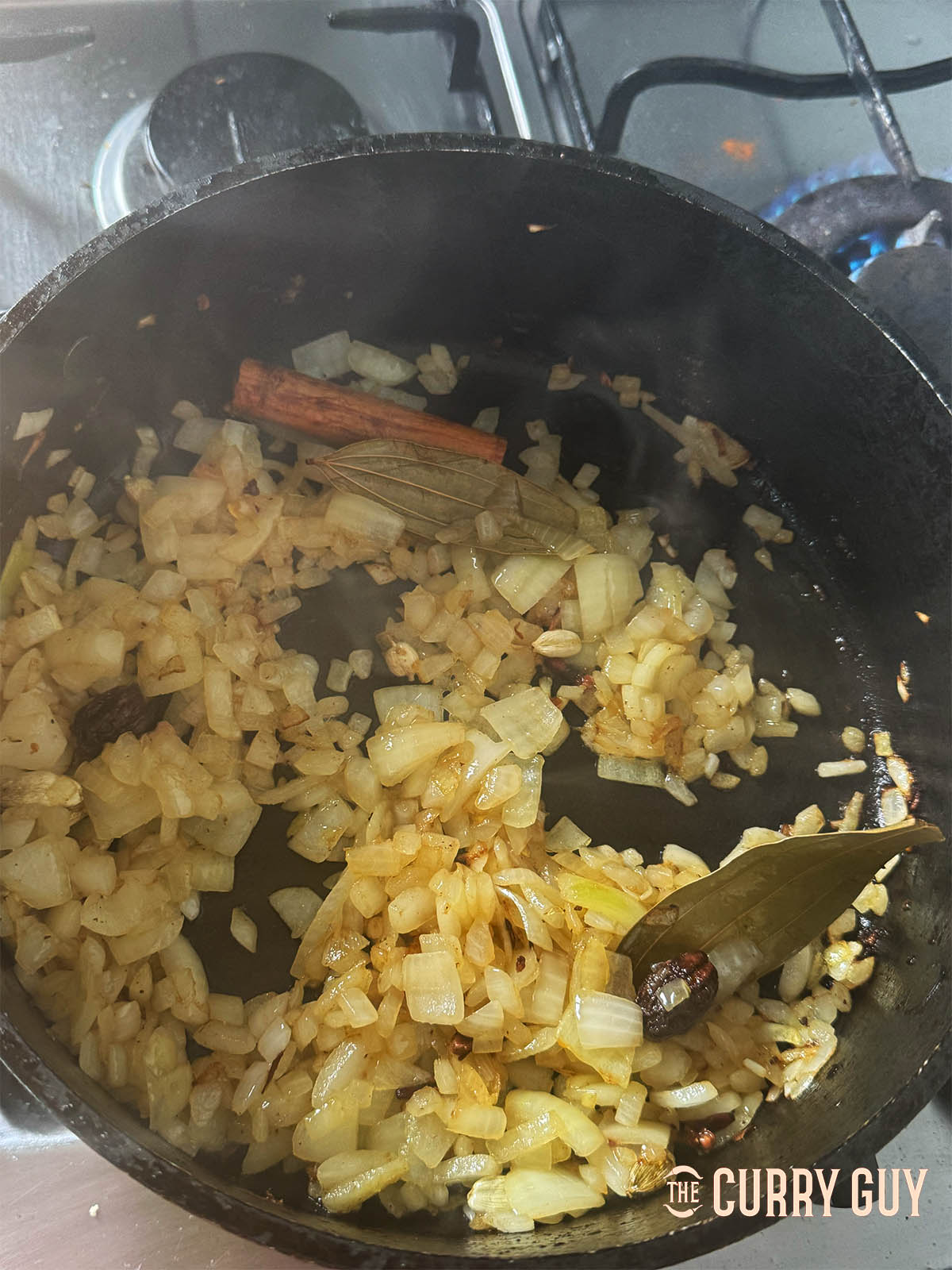 browning the onions in a pan with the ghee and whole spices.