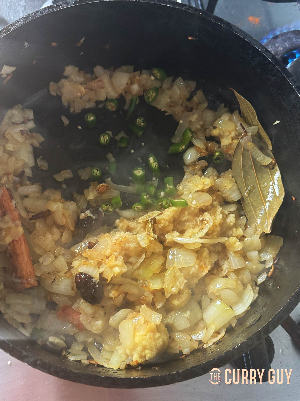 Stirring in the garlic and ginger paste along with the chopped green chillies.