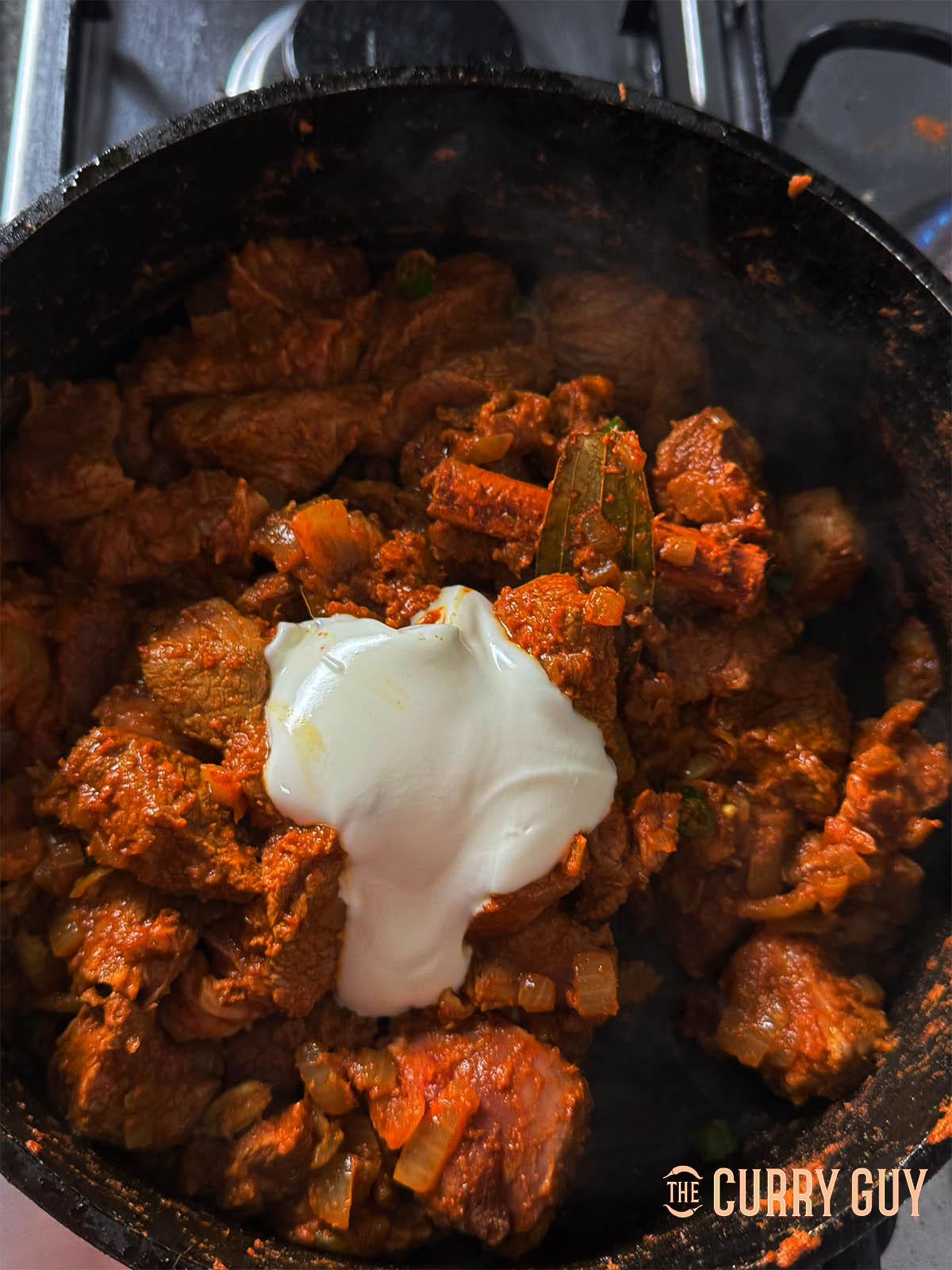 Adding the yoghurt to the seared lamb.