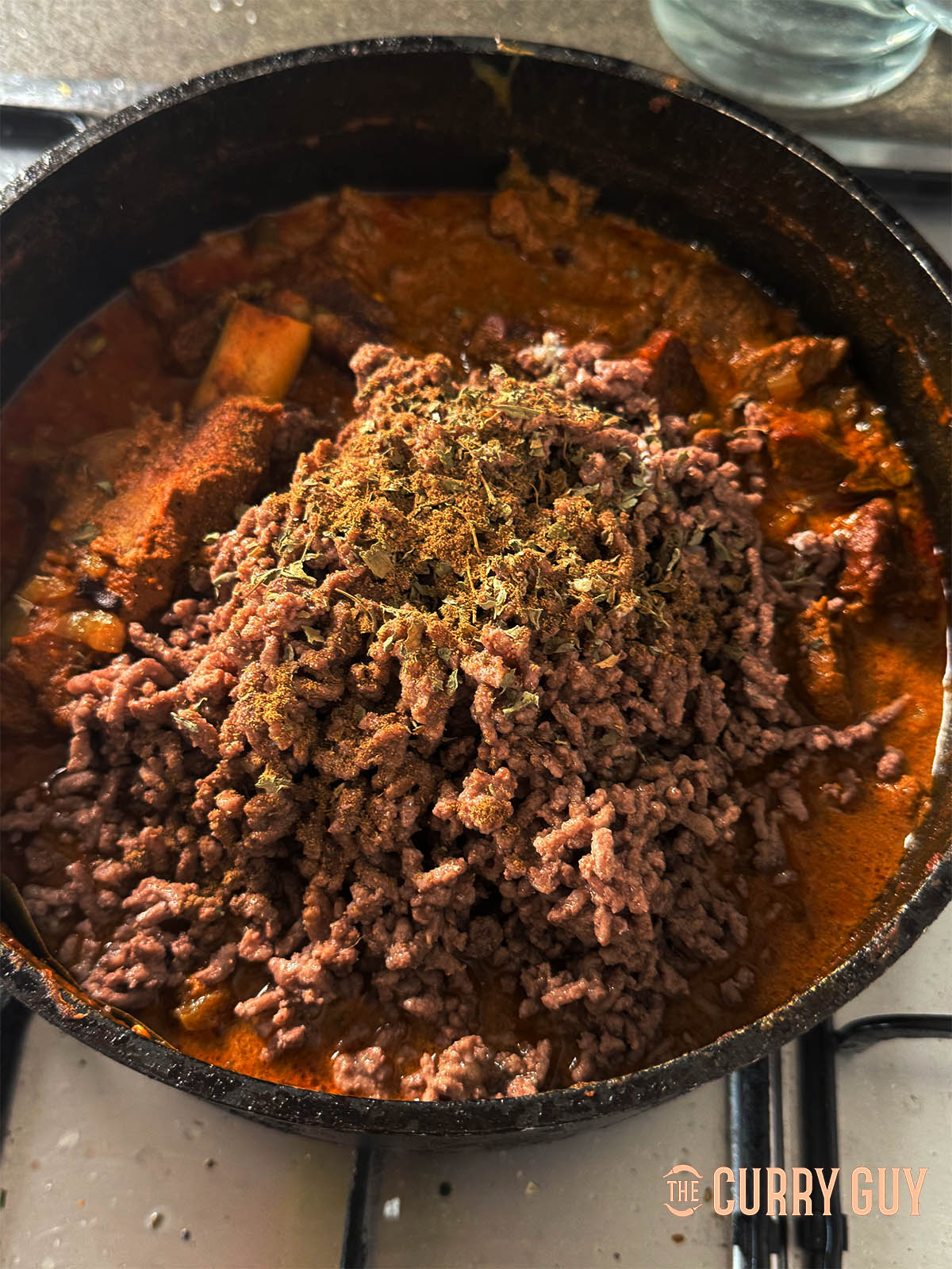 Returning the ground minced lamb to the pan.