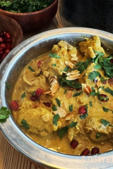 Chicken anarkali in a serving bowl, garnished with pomegranate seeds and coriander.