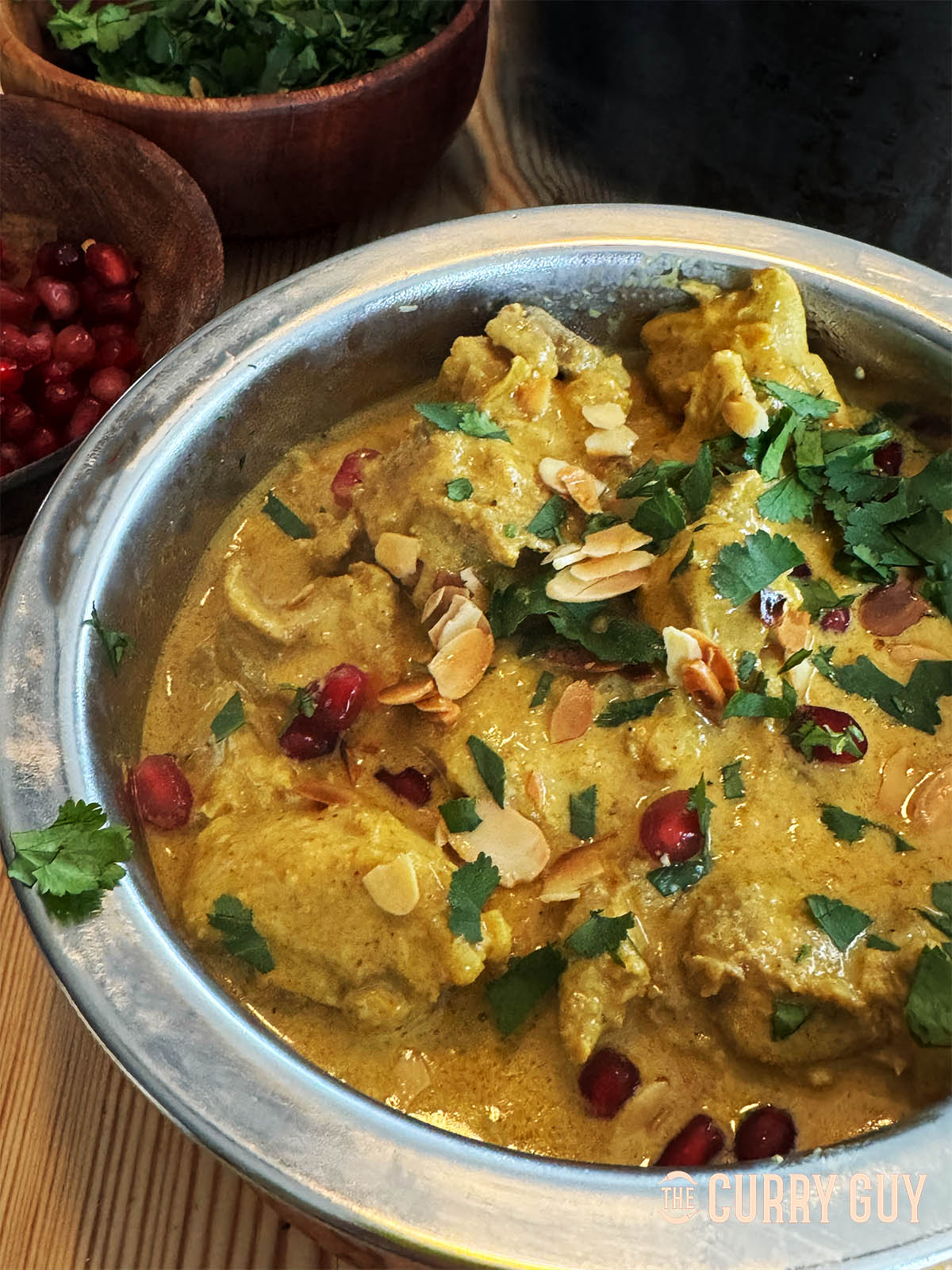Chicken anarkali in a serving bowl, garnished with pomegranate seeds and coriander.