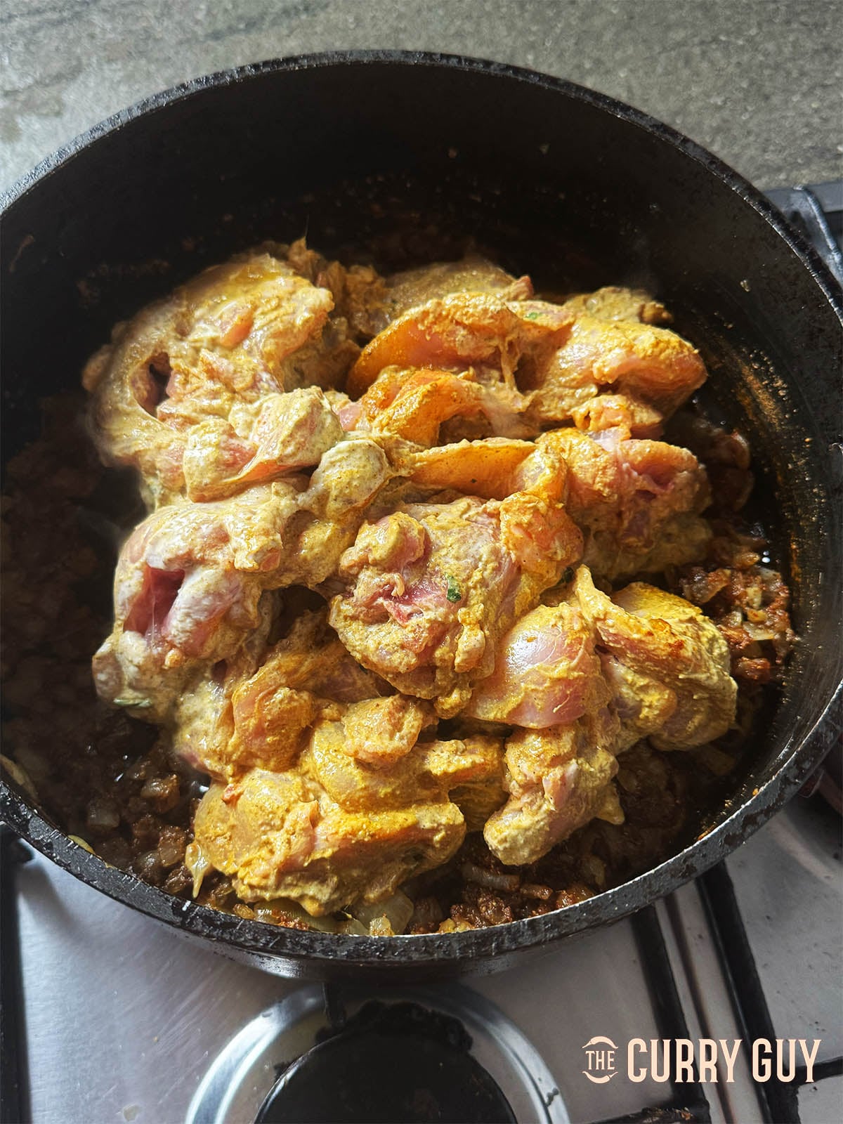 Adding the marinated chicken to the pan with all the marinade.