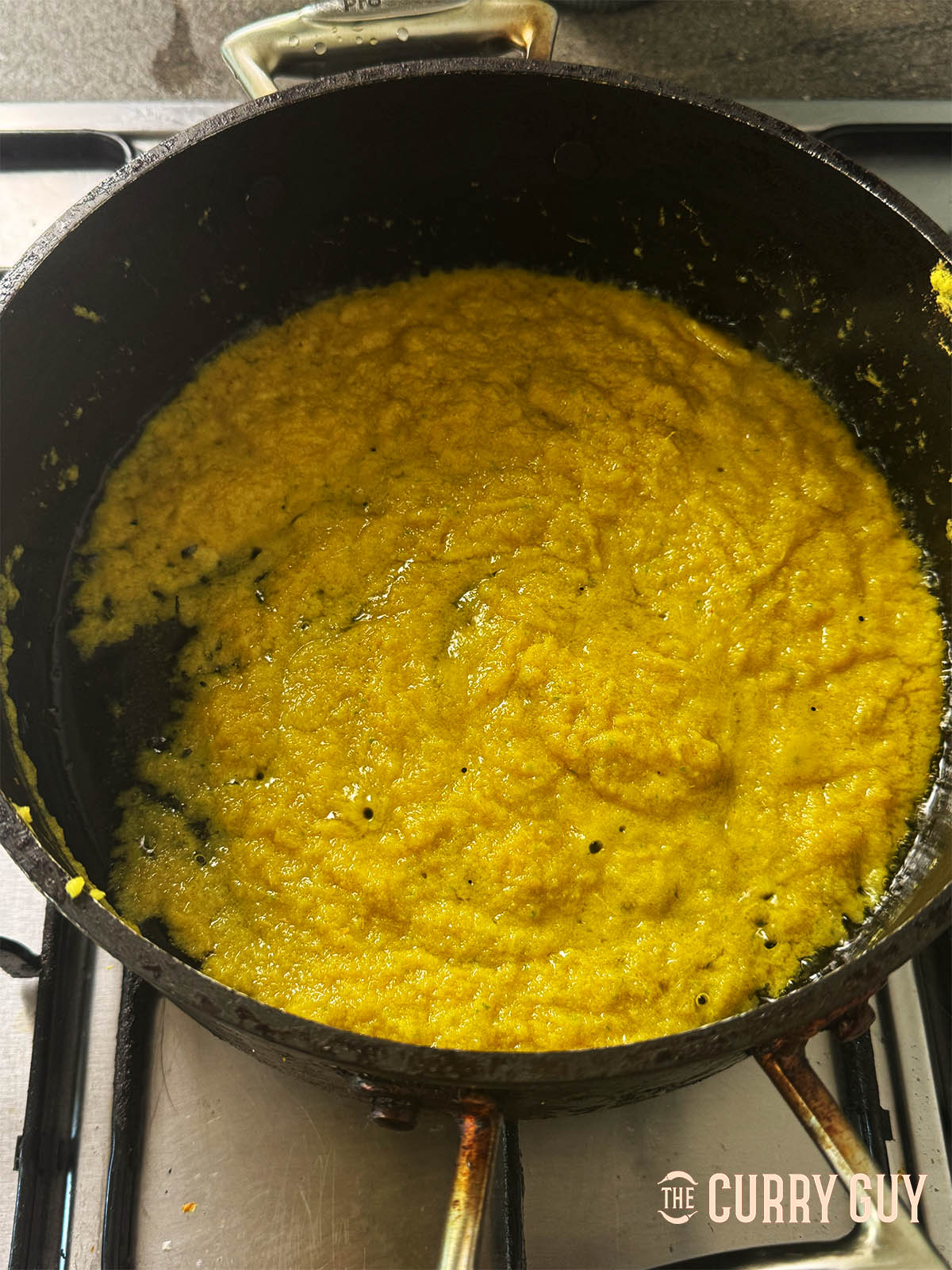 Starting to fry the green paste in a pan.