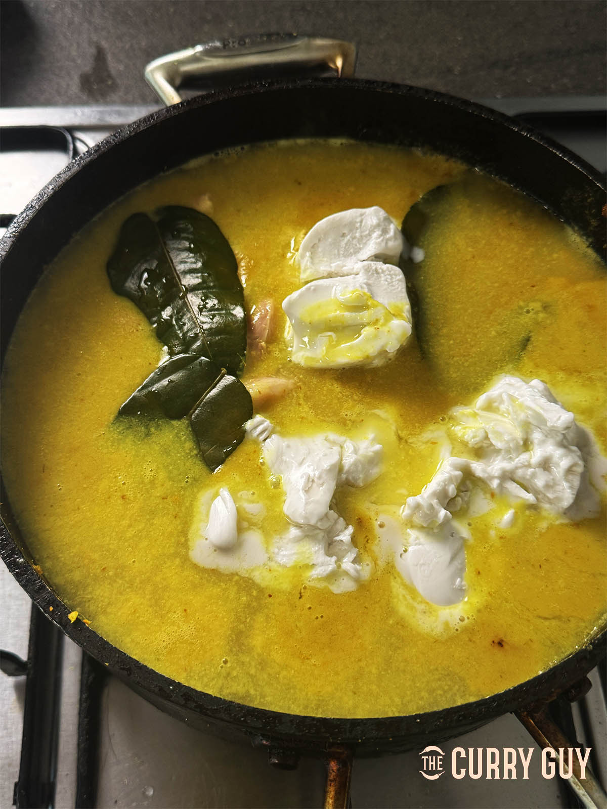 Adding the kaffir lime leaves to the sauce.