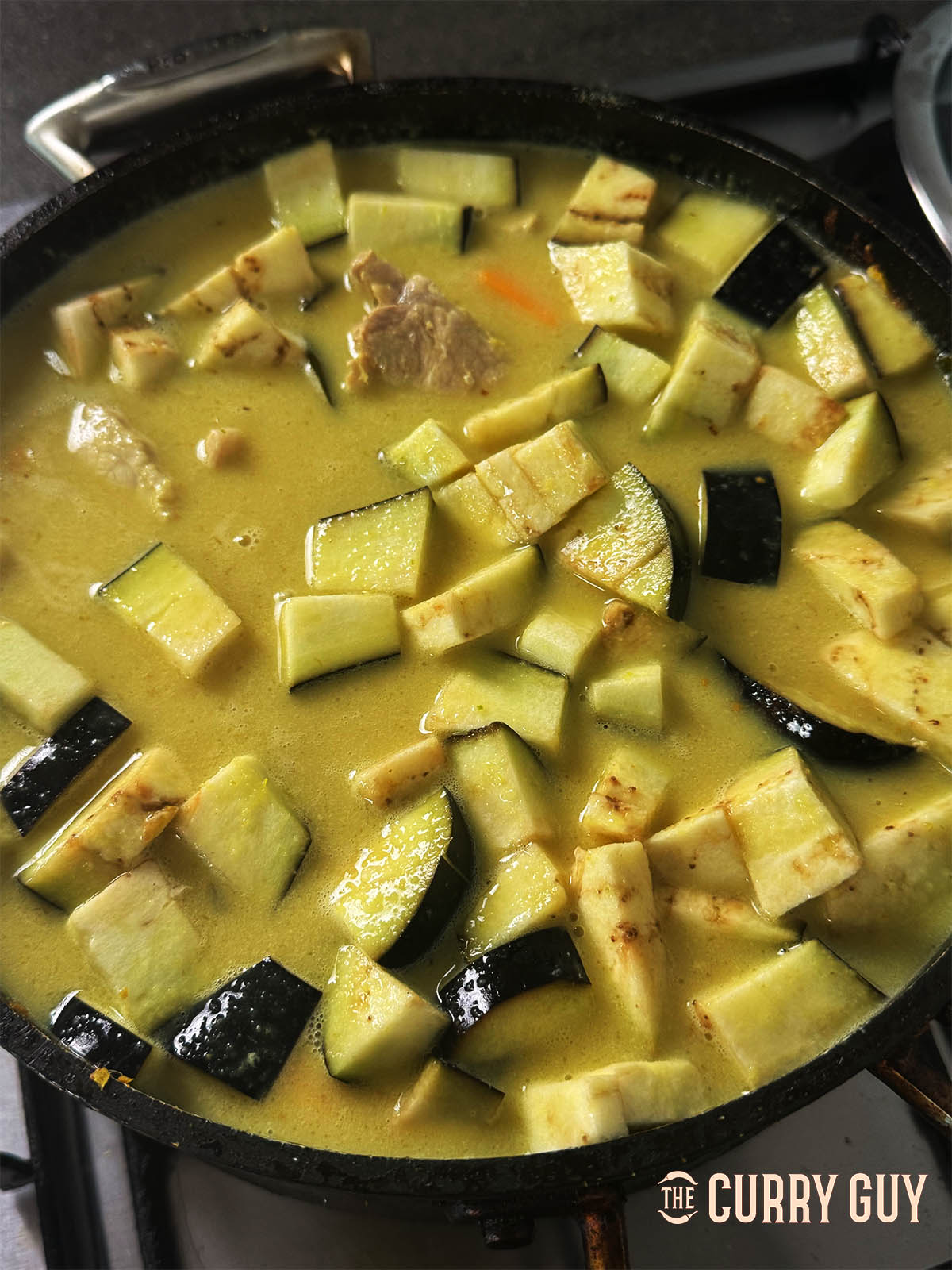 Adding the aubergine and pushing it right down into the sauce.