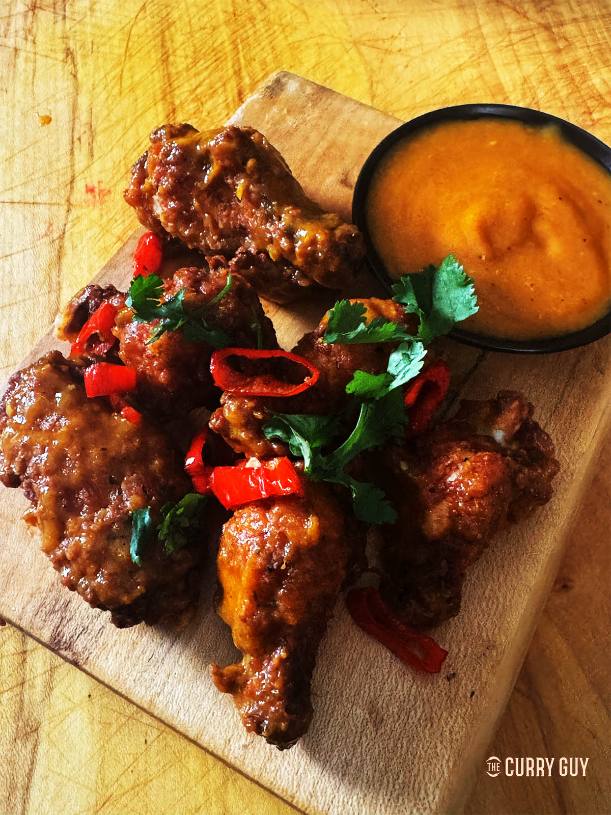 Habanero Chicken wings next to mango habanero sauce.