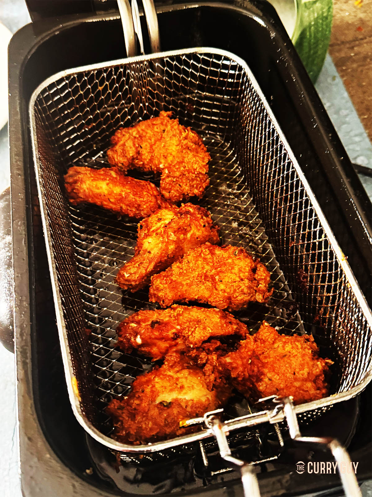 The cooked wings in a frying basket.