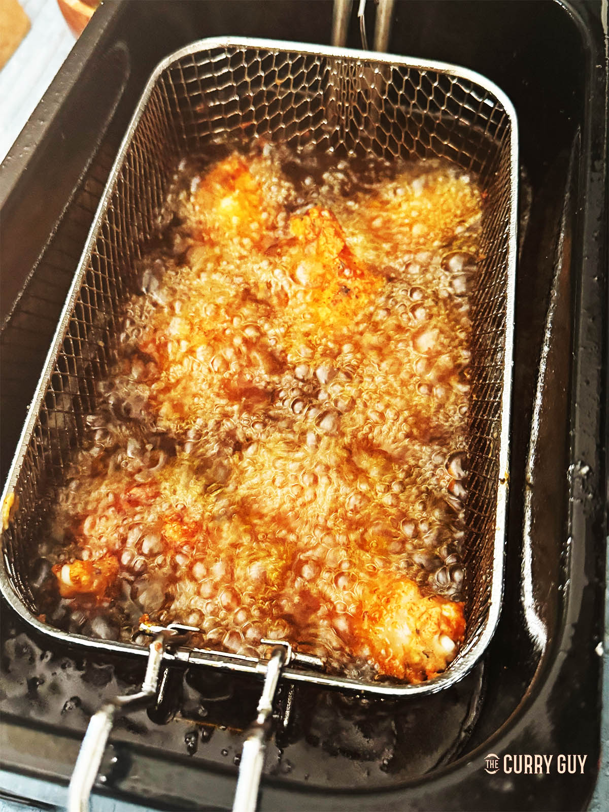 Frying the chicken wings in hot oil.