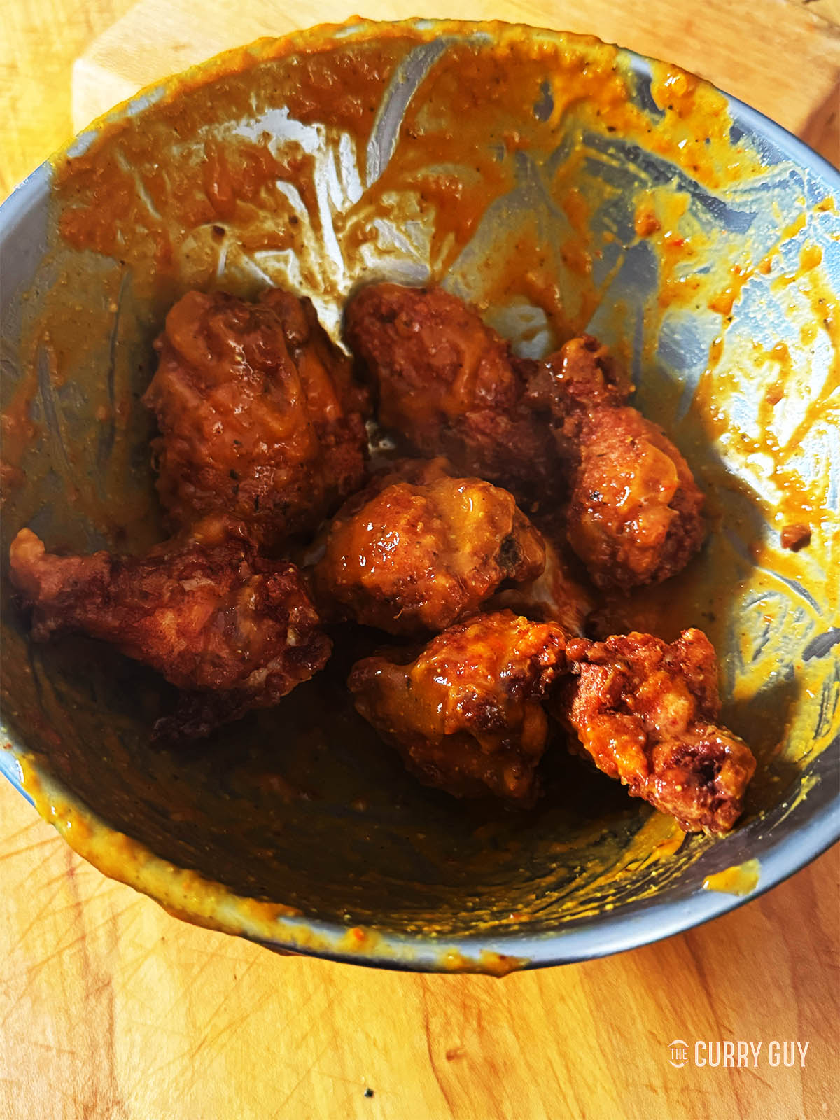 Tossing the chicken wings with the mango habanero sauce.