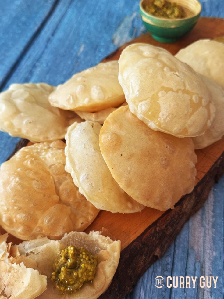 Puris served on a serving platter with chilli pickle.