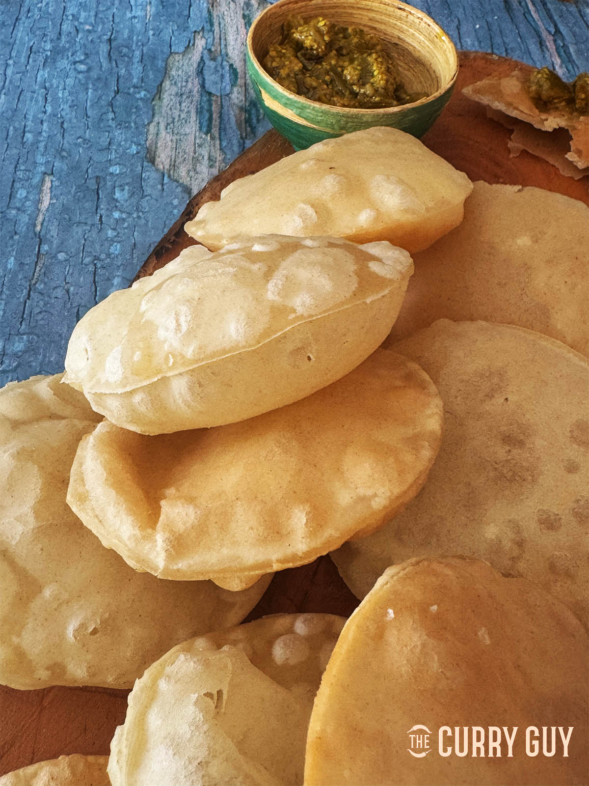 Finished easy puris on a serving board with chilli pickle
