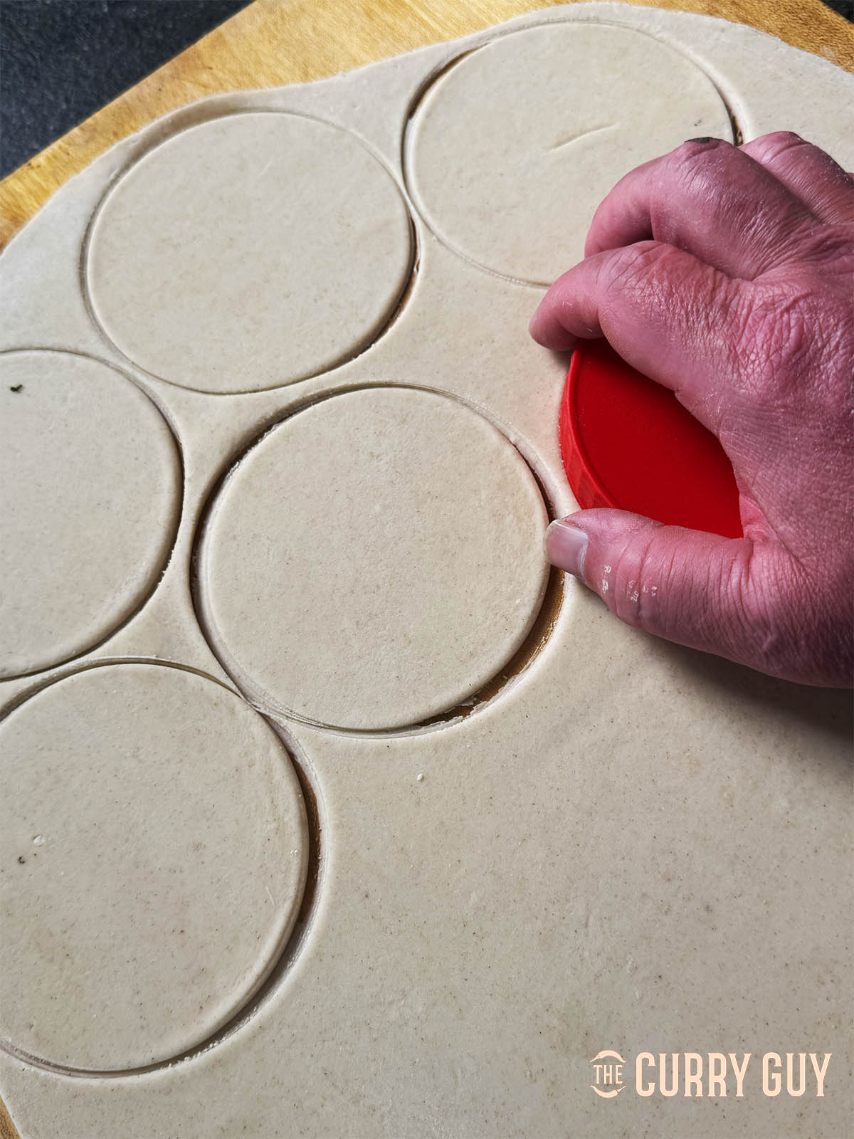Cutting round puris our of the dough sheet.
