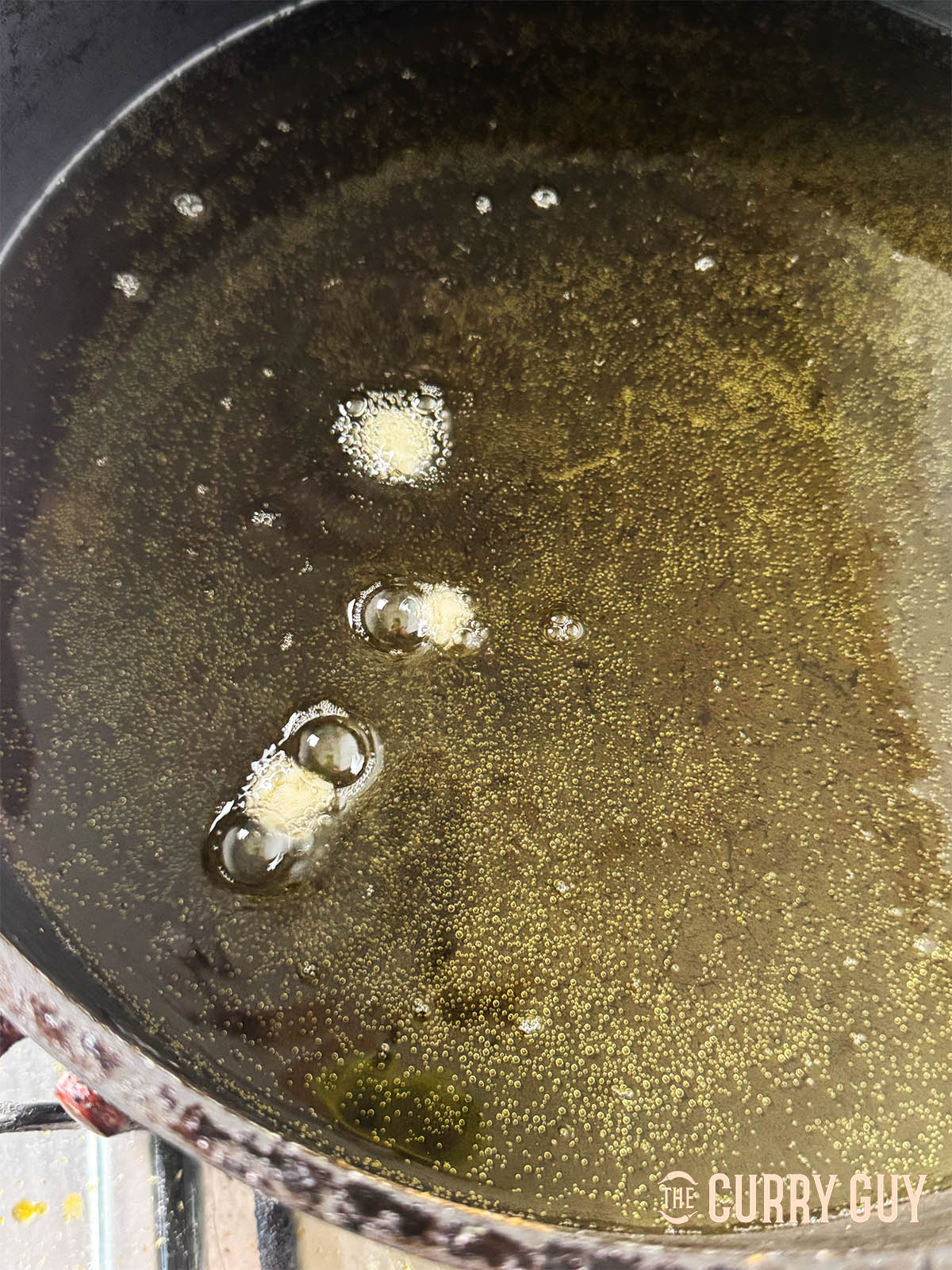 Testing the oil temperature by adding small dough pieces to the oil.