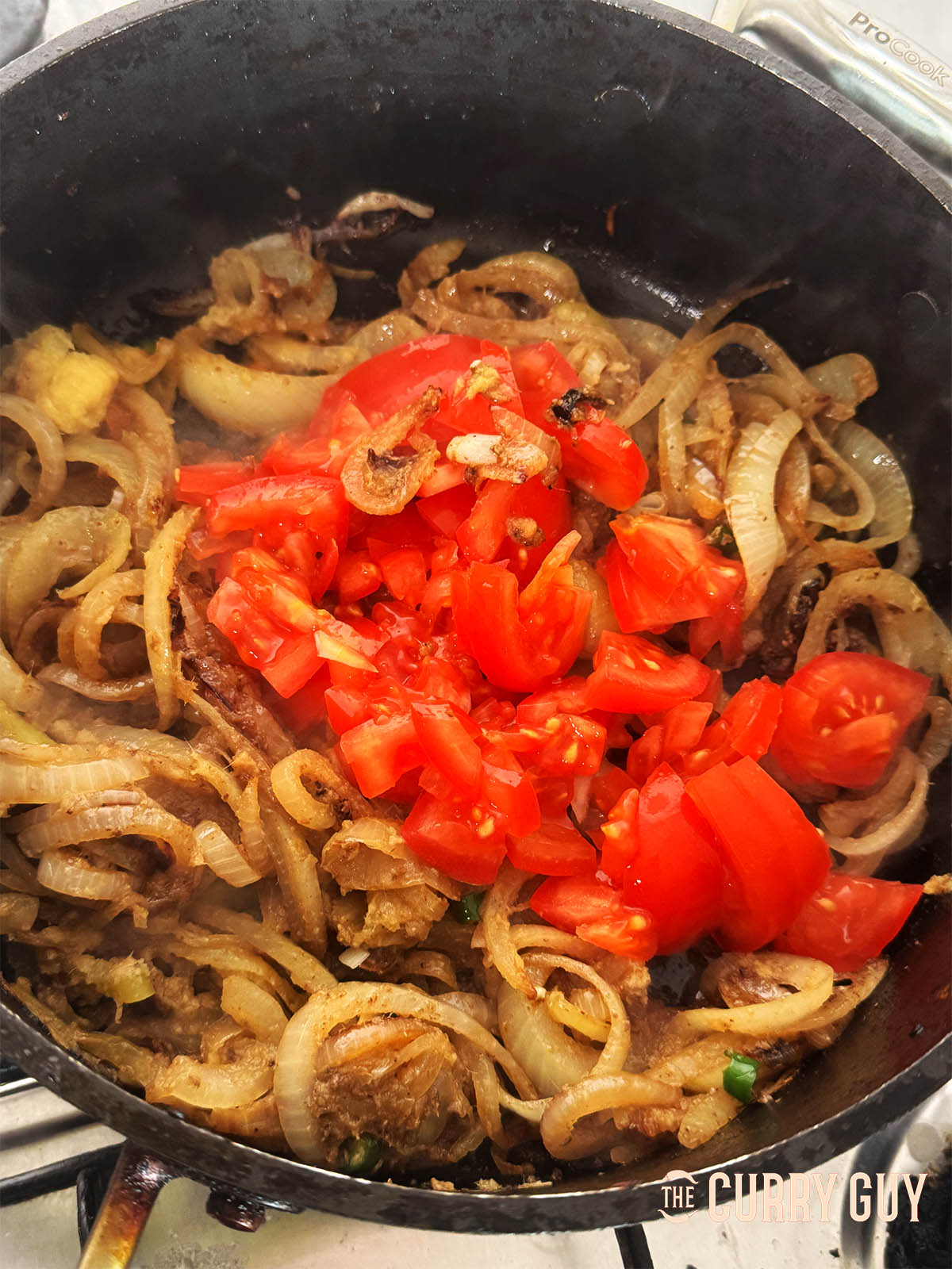 Stirring in the ground spices along with the chopped tomatoes.
