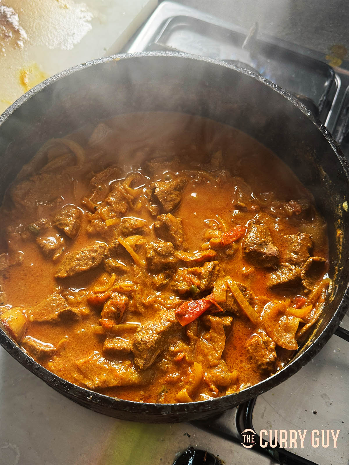 Cooking the curry down to thicken the sauce.
