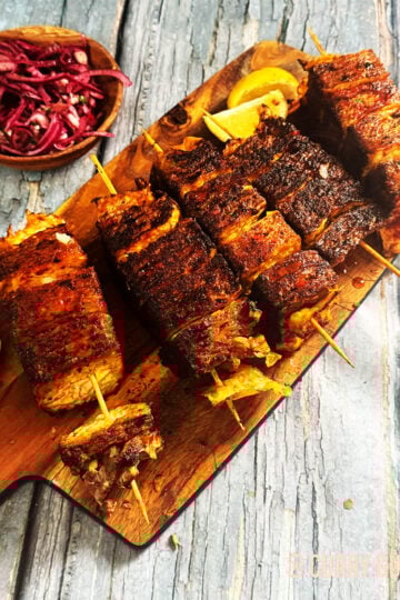 Beef lavash kebabs served on a serving board with onion salad.