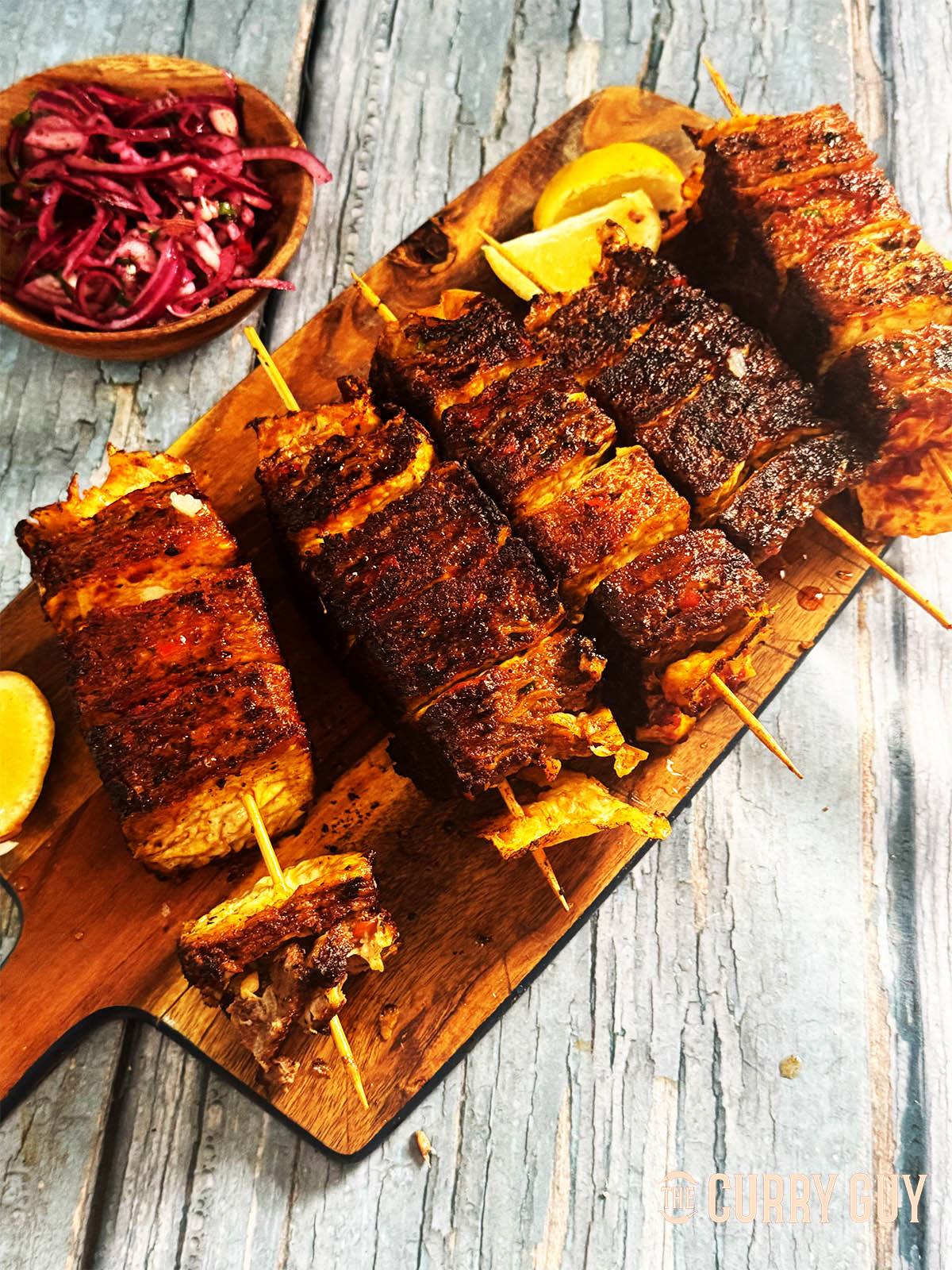 Beef lavash kebabs served on a serving board with onion salad.