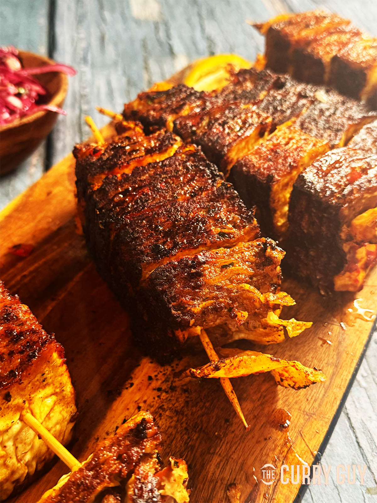 Lavash kebabs on a serving board with onion salad.