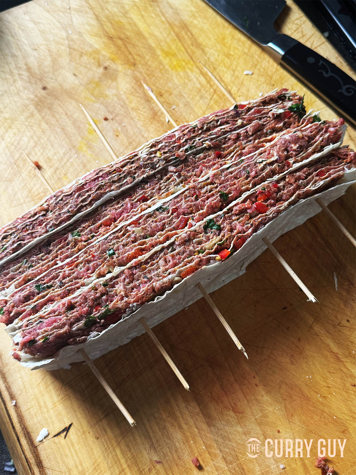 Turning the lavash and meat stacks on their side to skewer.