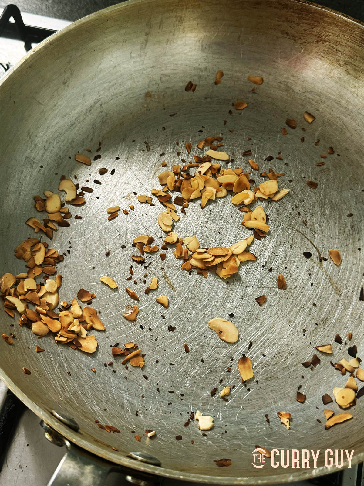 Toasting the almond flakes until golden brown in a pan.