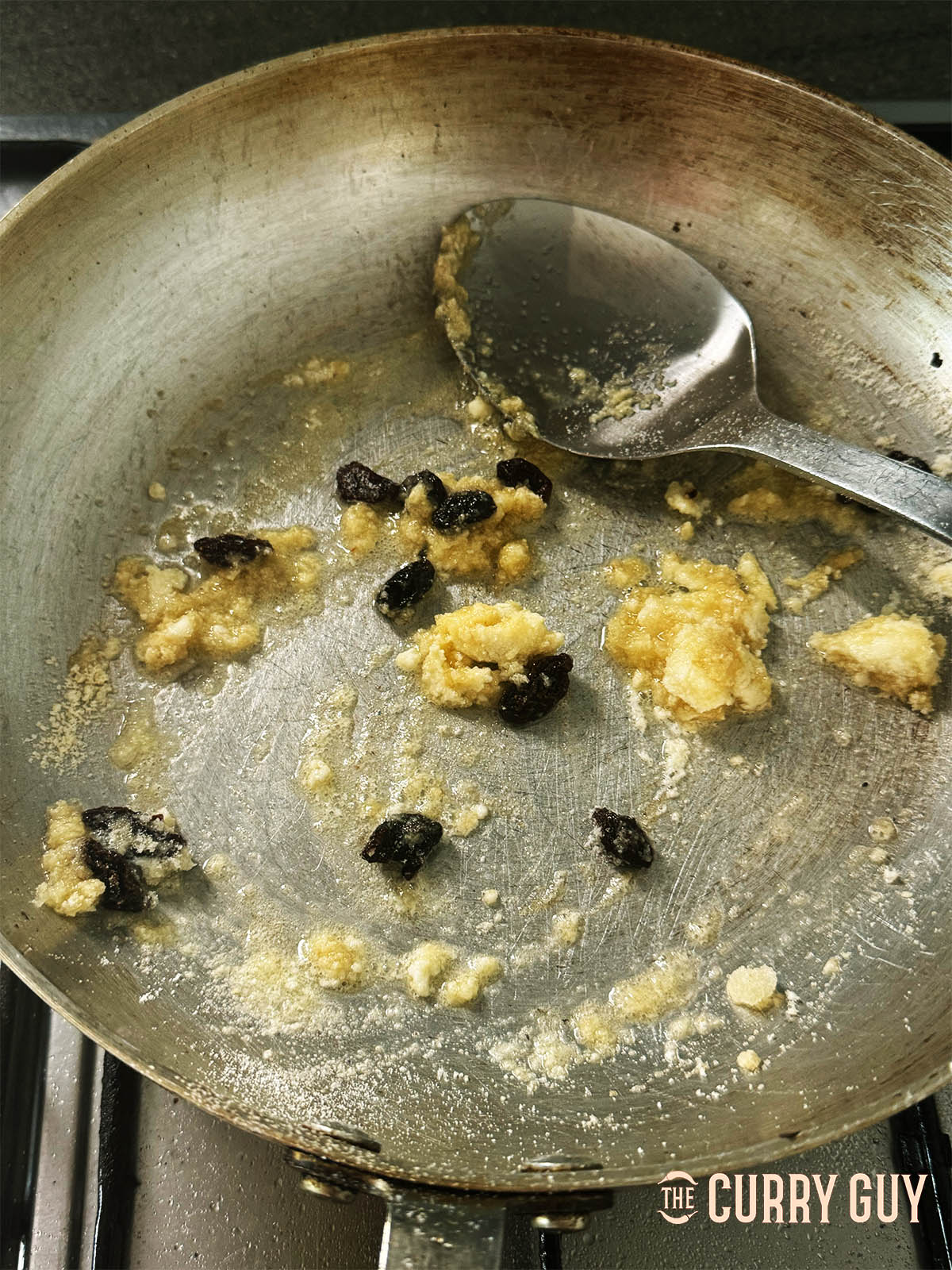 Adding the coconut flour, ground almonds and raisin or sultanas to the pan.