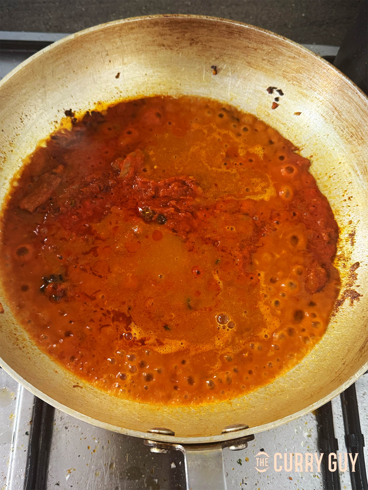Stirring in some base sauce and bringing to a simmer.