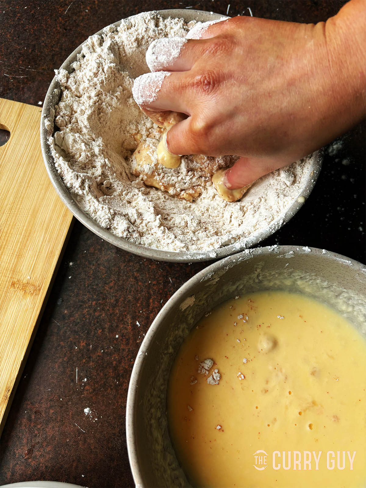 Dipping chicken into the flour mixture.